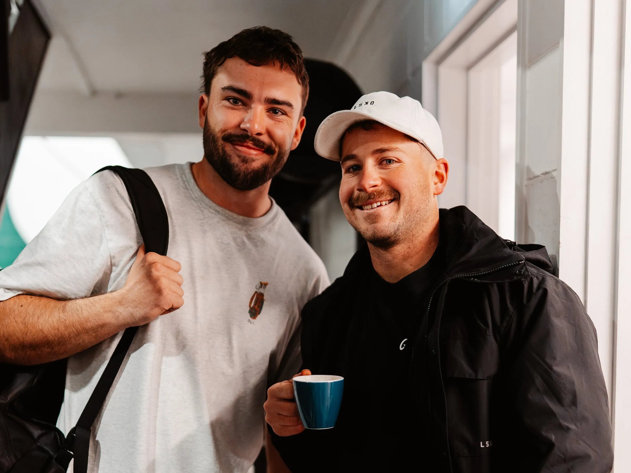 Two members heading out after a session — bags packed, coffee in hand.