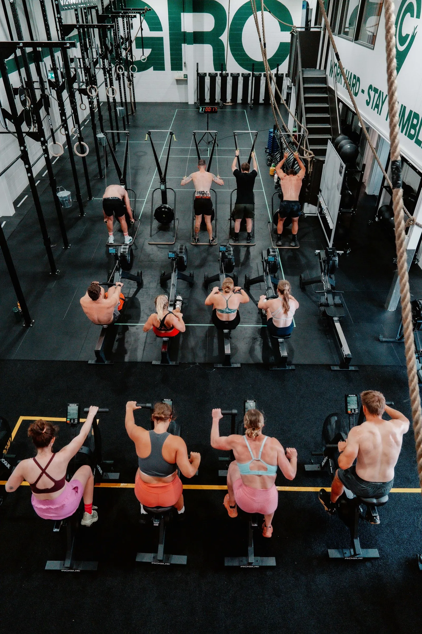 EMOM from above — rowers, bikes and pull-up stations working in formation.
